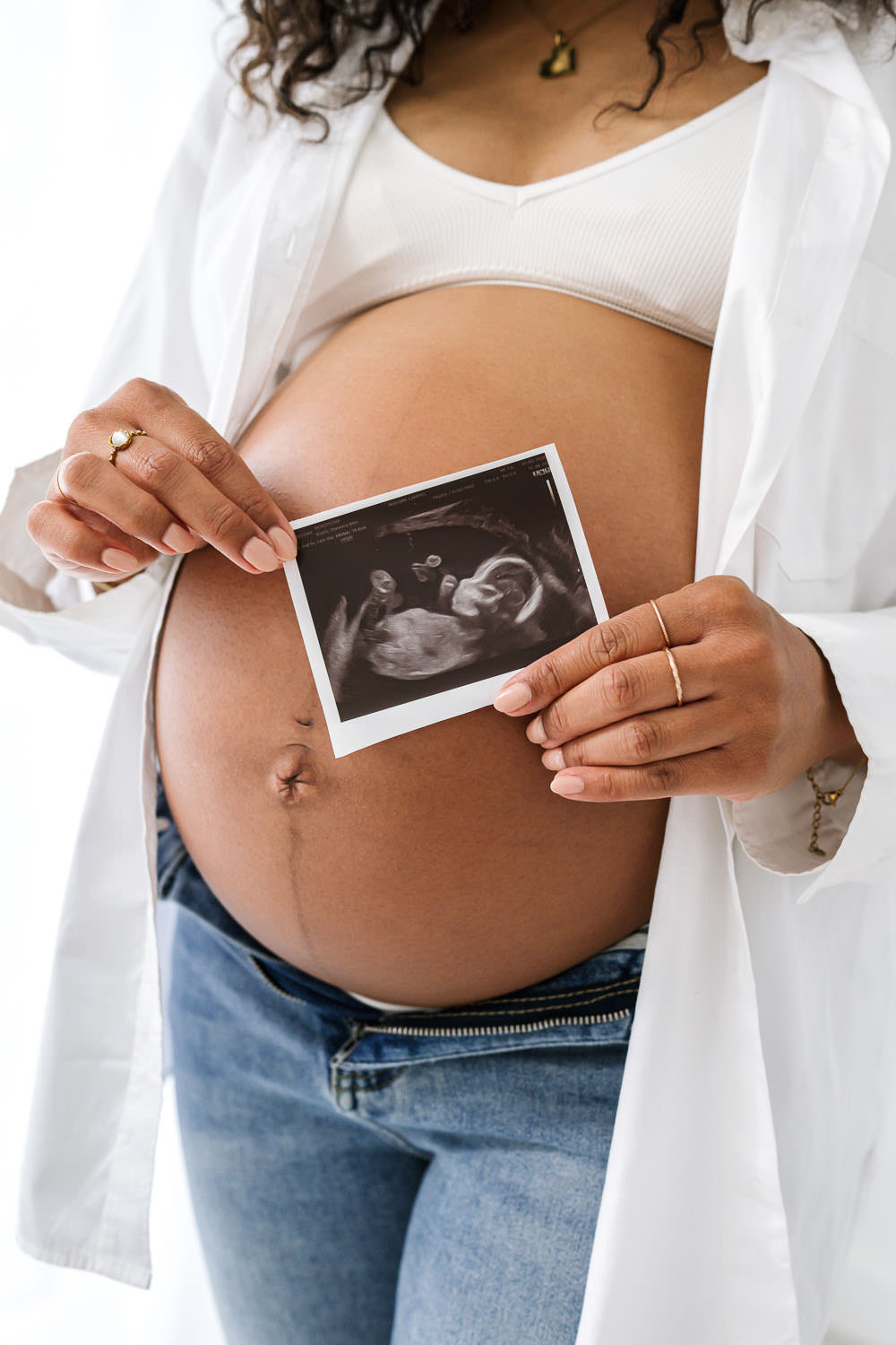 pregnant mother holding an ultrasound scan during a family photography session at The Rose Den in West Bridgford