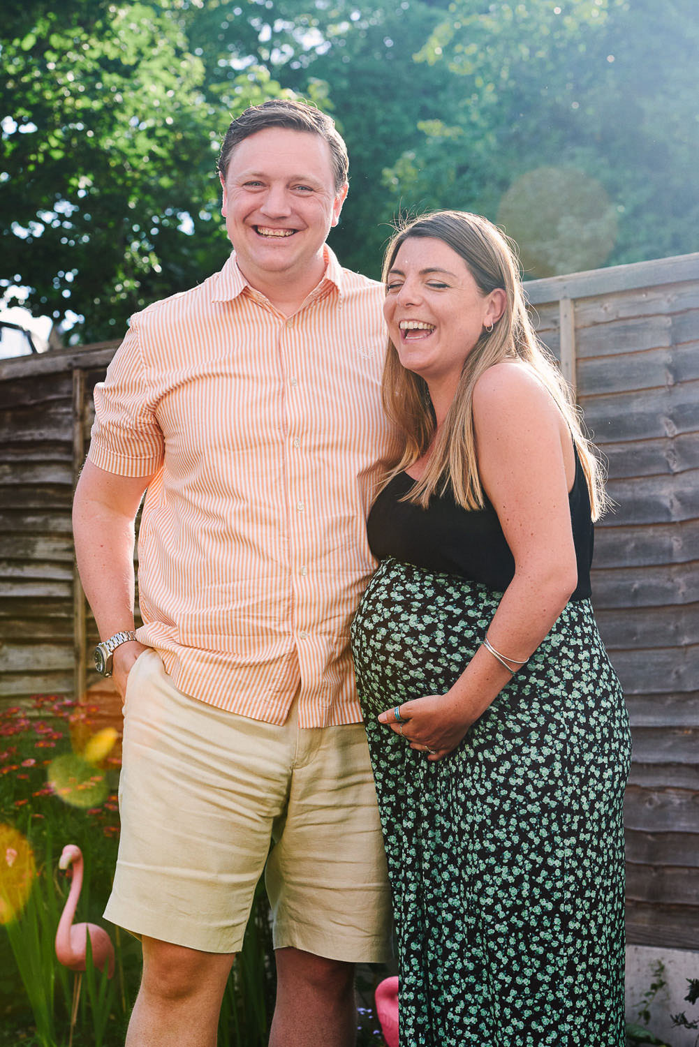 Pregnant woman standing with her partner in a garden during a natural pregnancy photography session in Nottingham